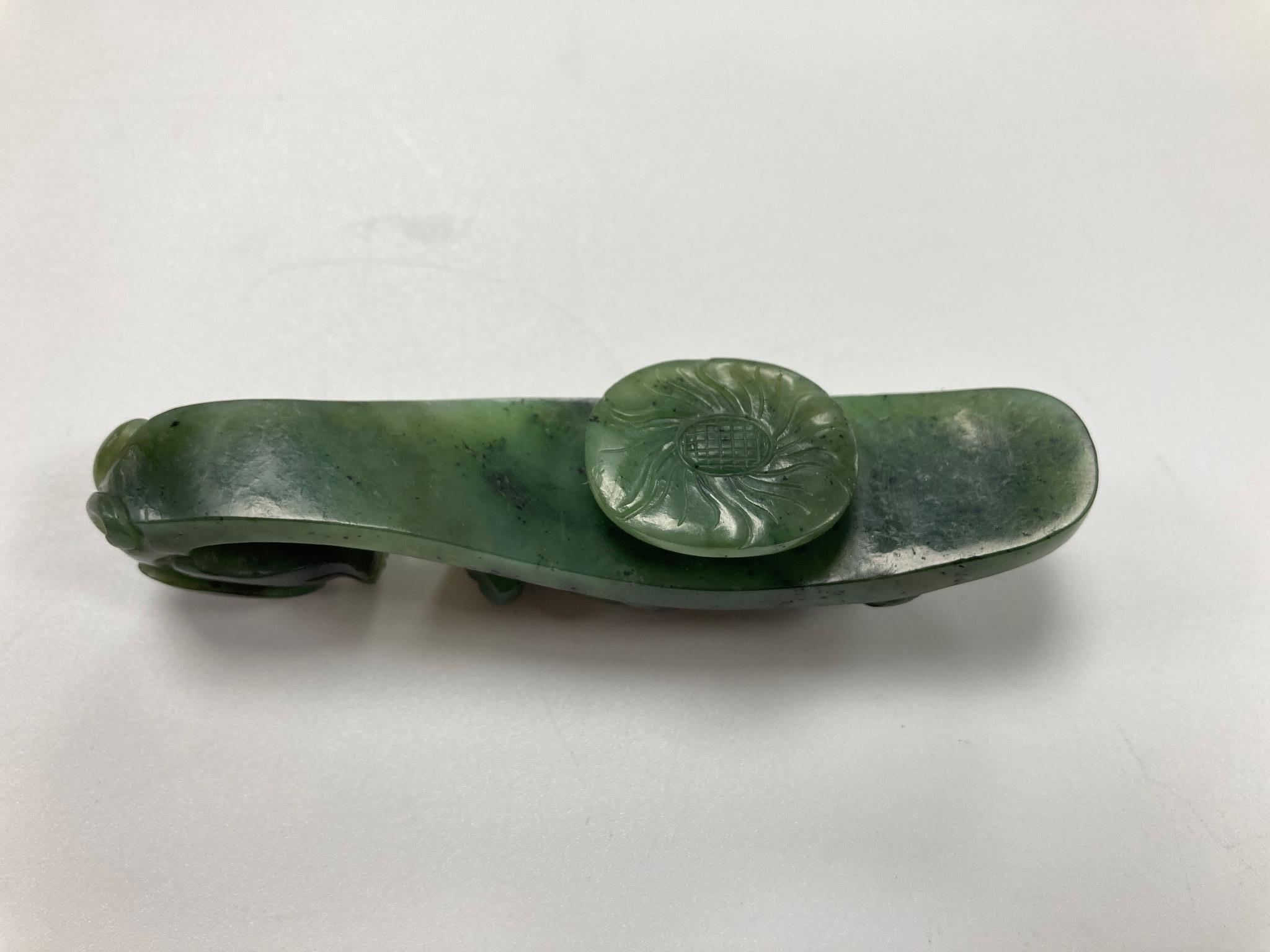 A Chinese bright spinach green jade ‘dragon’ belt hook, 18th/19th century, 9.5cm long